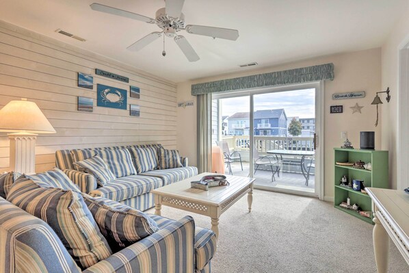 A living room with striped sofas, a coffee table, and a green shelf. - Pool, Canal Views! Unit 1/2 Mi to Ocean City Beach (Ocean City)