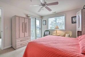 A bedroom with a bed, a wardrobe, a ceiling fan, a window with blinds, and a chair. - Pool, Canal Views! Unit 1/2 Mi to Ocean City Beach (Ocean City)