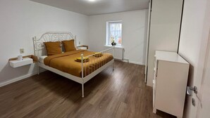 Una camera da letto con un letto, un comodino, una finestra e un armadio.