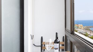 A balcony with a table set for two, a bottle of Vina Tinto, and a wine glass. - Seafront San Andres (Santa Cruz de Tenerife)