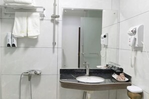 A modern bathroom with a sink, mirror, towel rack, and a hairdryer. - Yuehai Holiday Hotel (Shanwei)