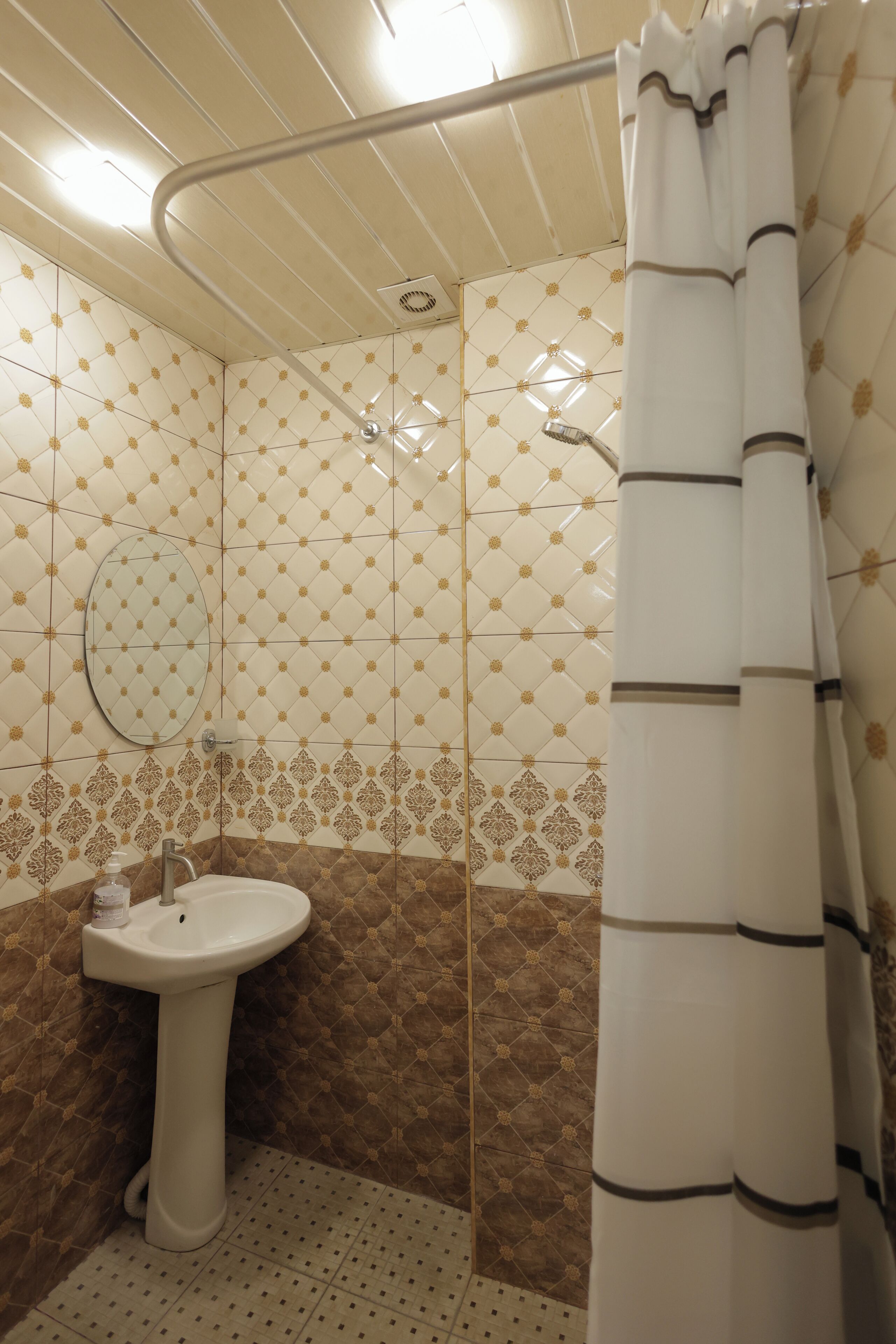 A bathroom with a shower, a sink, and a mirror.