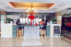 A hotel reception area with a chandelier, reception desk, and a digital screen. - Meiyi Meijia Hotel (Xiangyang Nanzhang) (Nanzhang)