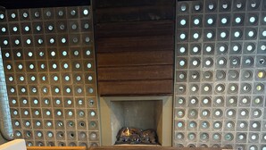 Un rincón acogedor con chimenea, asientos mullidos y un tapiz estampado.