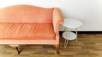 A room with a peach-colored sofa and a small white table with gold legs.