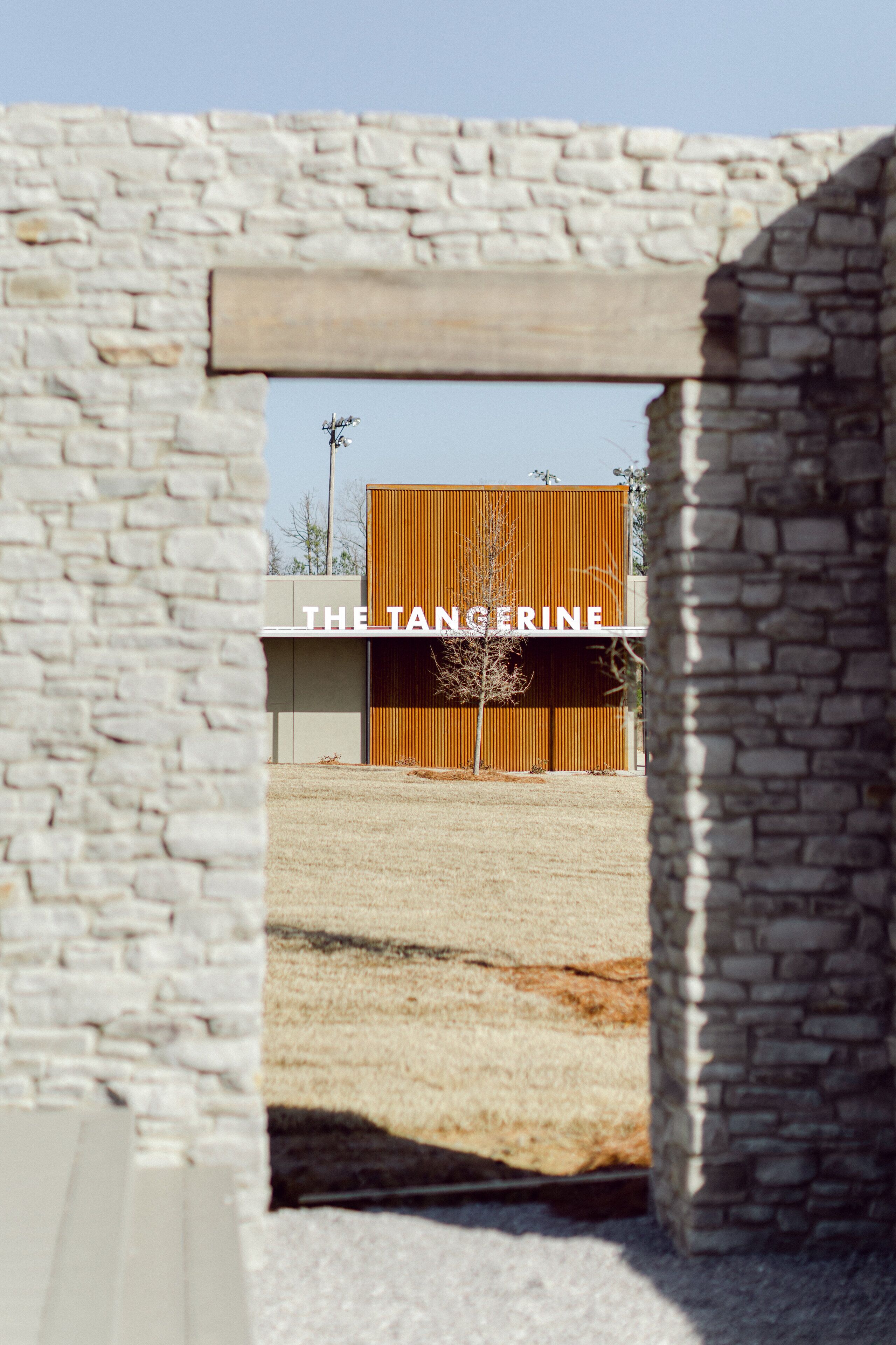 A modern building with a wooden facade and a stone archway.