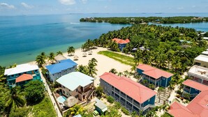 Un resort con varias construcciones, una playa y vistas al océano.
