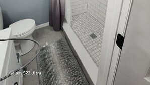 Un bagno con doccia, WC e lavandino.