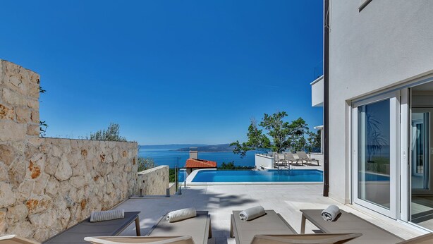 A modern outdoor pool area with lounge chairs and a clear view of the sea. - Villa Simply White with Pool (Makarska)