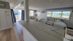 Amplia sala de estar con una isla grande de mármol, un sofá y una mesa de comedor.