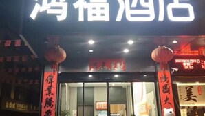 Une enseigne d’hôtel avec des caractères chinois, indiquant le nom de l’établissement.