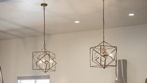 A modern kitchen with a large island, bar stools, pendant lights, and a stainless steel range hood. - Overlake: Private Pool + Large Groups + Sand Dunes (Hurricane)