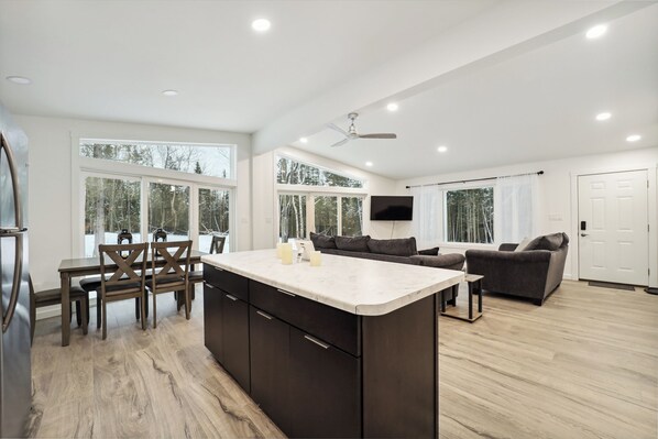 Relax in a spacious living area with a central island, comfortable seating, and a well-equipped kitchen.