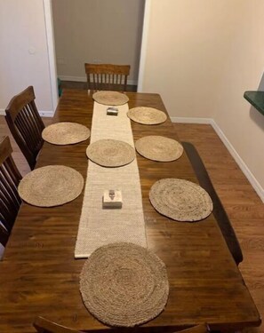 Enjoy meals with family and friends in this spacious dining area, featuring a long wooden table and comfortable chairs.