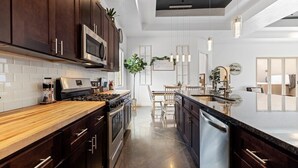 A modern kitchen with dark wood cabinets, stainless steel appliances, and a wooden countertop. - Bridgewood: Private Hot Tub + Golf + Sand Dunes (Hurricane)