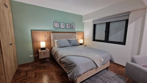 A bedroom with a bed, bedside tables, a window, and a wardrobe. - Unique Apartment-1/BR-1/BATH-Miraflores- Ocean/Park-Views (Lima)