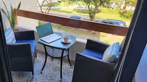 A balcony with wicker furniture, a laptop, and a cup. - Unique Apartment-1/BR-1/BATH-Miraflores- Ocean/Park-Views (Lima)