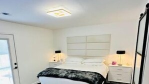 A bedroom with a bed, bedside tables, a door, and a ceiling light. - Escape to Comfort in Lexington/Hamburg: Stylish 3BR/2.5BA Home (Lexington)