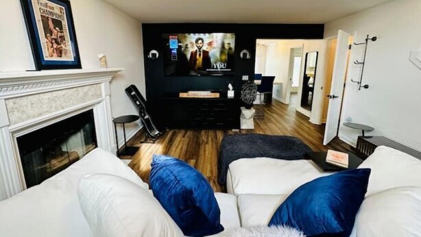 A living room with a fireplace, a TV, and a seating area with a couch and ottoman. - Escape to Comfort in Lexington/Hamburg: Stylish 3BR/2.5BA Home (Lexington)
