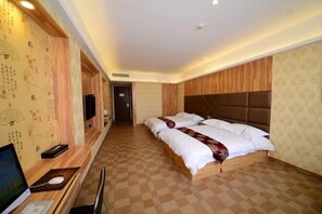 A hotel room with a checkered floor, a bed with white bedding and a brown headboard, a desk with a computer, and a television. - Nuoman Holiday Hotel (Xiantao)