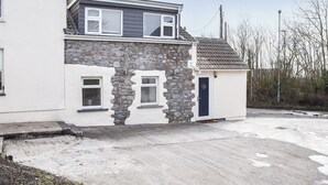 A two-story house with a stone facade and a grey roof.