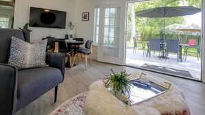 Una sala de estar moderna con un sofá, una mesa de centro y un comedor con sillas y una mesa.