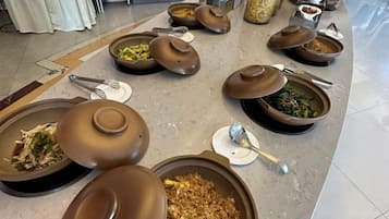 A buffet setup with various dishes and serving utensils.