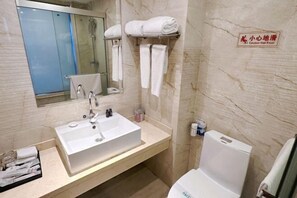 A modern bathroom with a large sink, mirror, and towel rack.