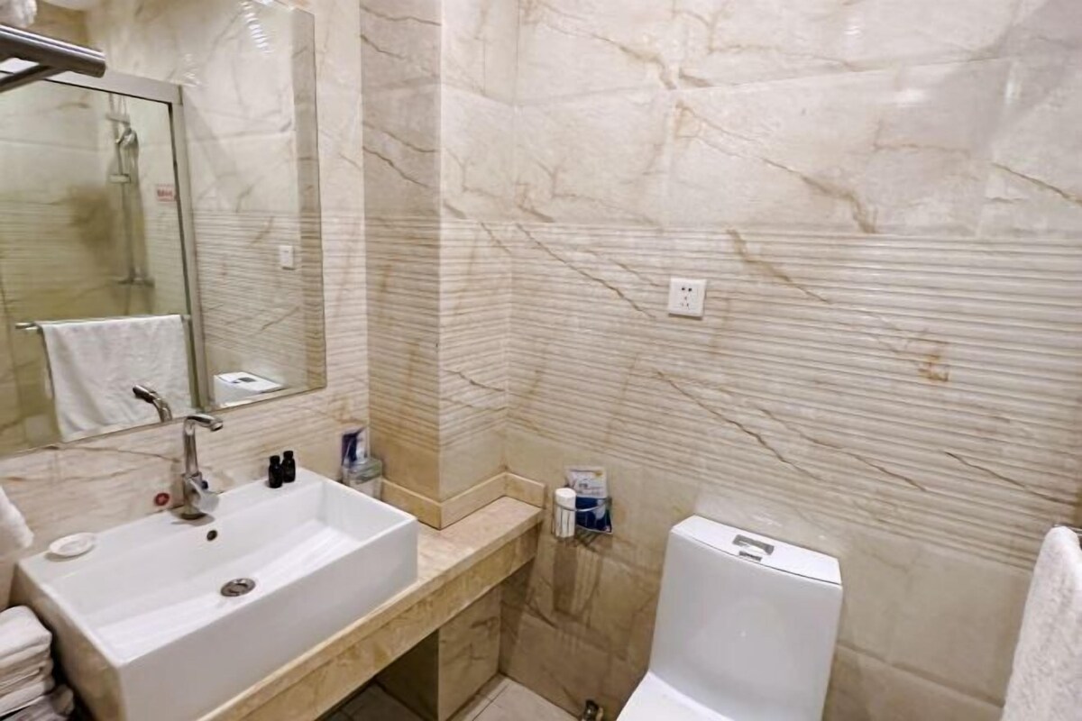 Une salle de bain équipée d’un lavabo, d’un miroir, de toilettes et d’une douche.