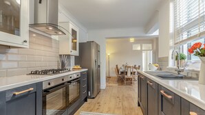 A modern kitchen with a central island, built-in oven, and stainless steel appliances. - 6 bedroom accommodation in Ramsgate (Ramsgate)