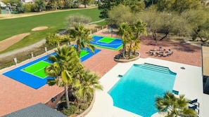 A pool area with a basketball court and palm trees. - Pickleball | Basketball | Game Room | Golf Course (Scottsdale)