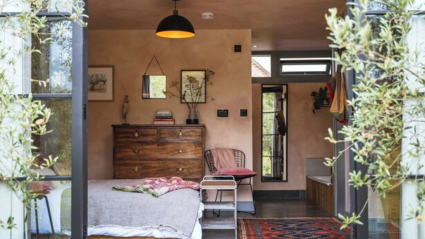 A bedroom with a bed, dresser, chair, and a hanging light fixture. - 1 bedroom accommodation in Willington, near Tarporley (Willington, near Tarporley)