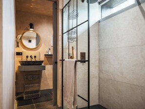 A modern bathroom with a round mirror, a sink, and a towel rack. - 1 bedroom accommodation in Willington, near Tarporley (Willington, near Tarporley)