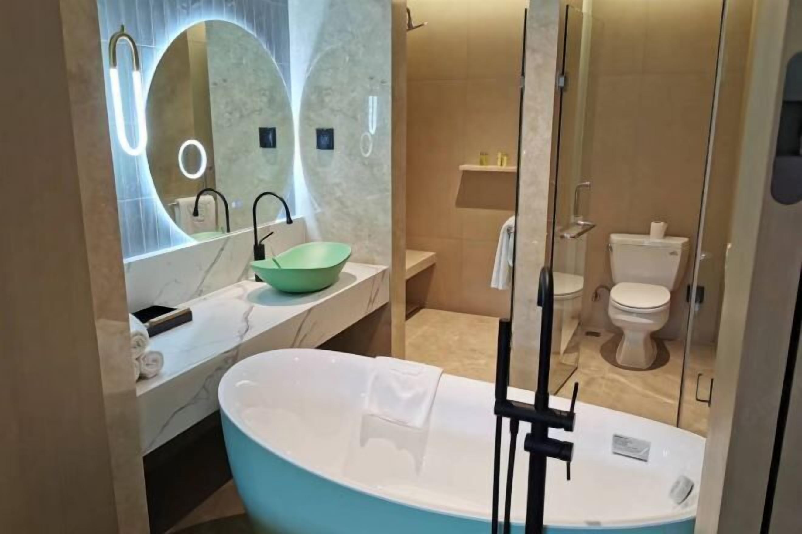 A modern bathroom with a freestanding bathtub, a large mirror, and a glass-enclosed shower area.