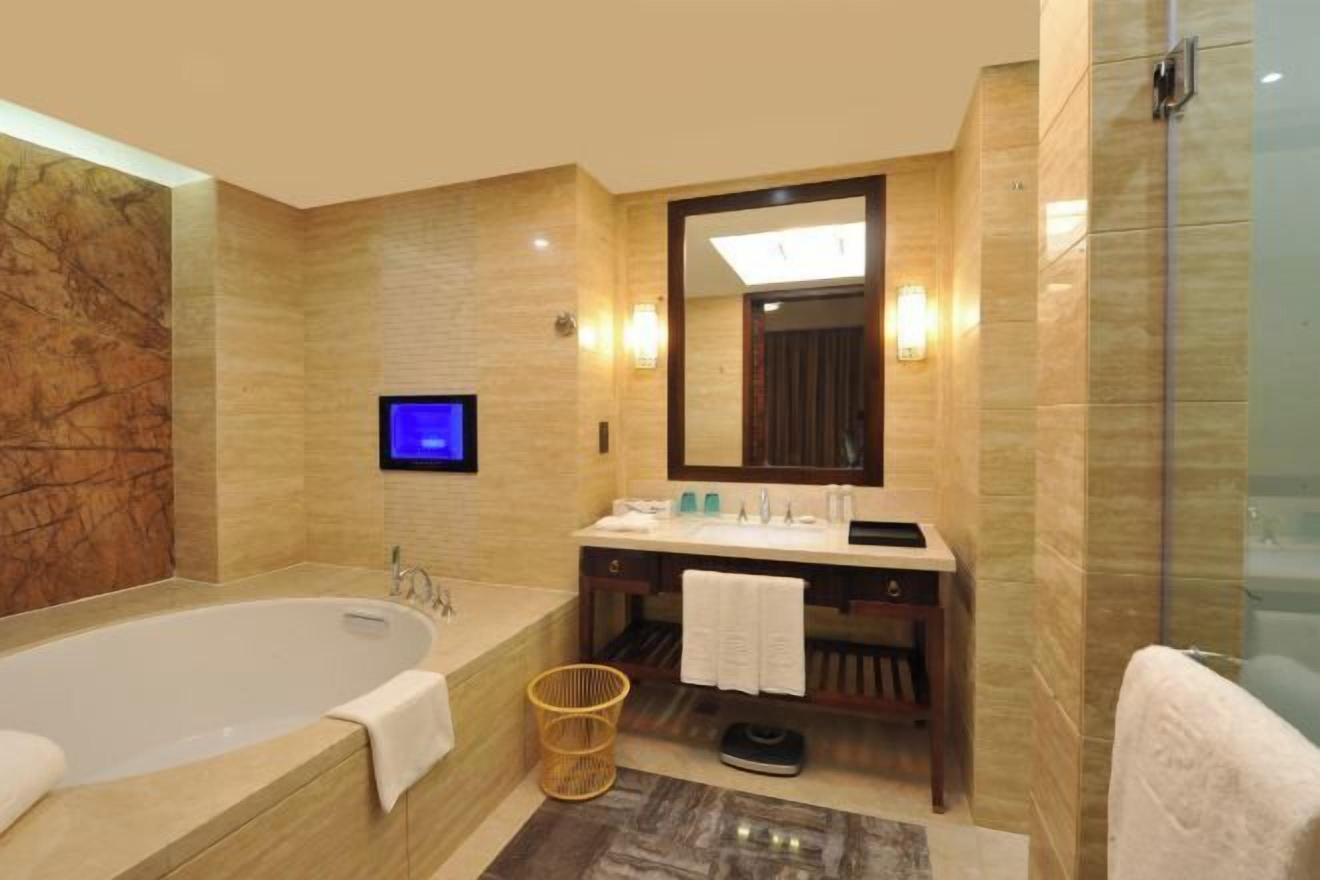 A modern bathroom with a large bathtub, a vanity with a mirror, and a shower area.