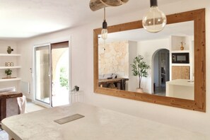 Un interior moderno con un espejo grande, vigas de madera, una pared de piedra y un diseño minimalista.
