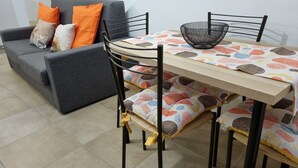 Un coin repas avec une table dressée pour quatre personnes, entourée de chaises.