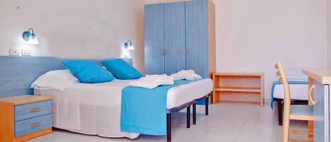 A bedroom with a bed, two bedside tables, a wardrobe, and a desk.