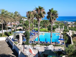 A resort with a swimming pool, lounge chairs, and palm trees. - Picchio Hotel Pescoluse (Salve)
