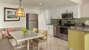 A modern kitchen with white cabinets, stainless steel appliances, and a green island. - DOWNTOWN KEY WEST 2BED OCEANFRONT! (Key West)