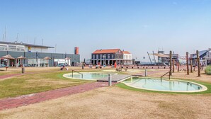 A public square with a pool, benches, and a building with a red roof. - Stunning apartment in Bruinisse (Bruinisse)