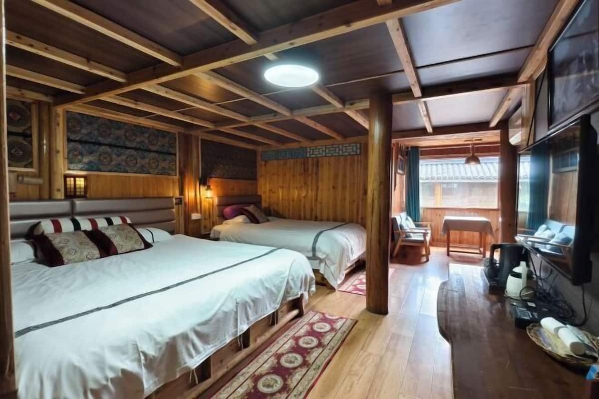 A wooden cabin with two beds, a TV, and a dining area.