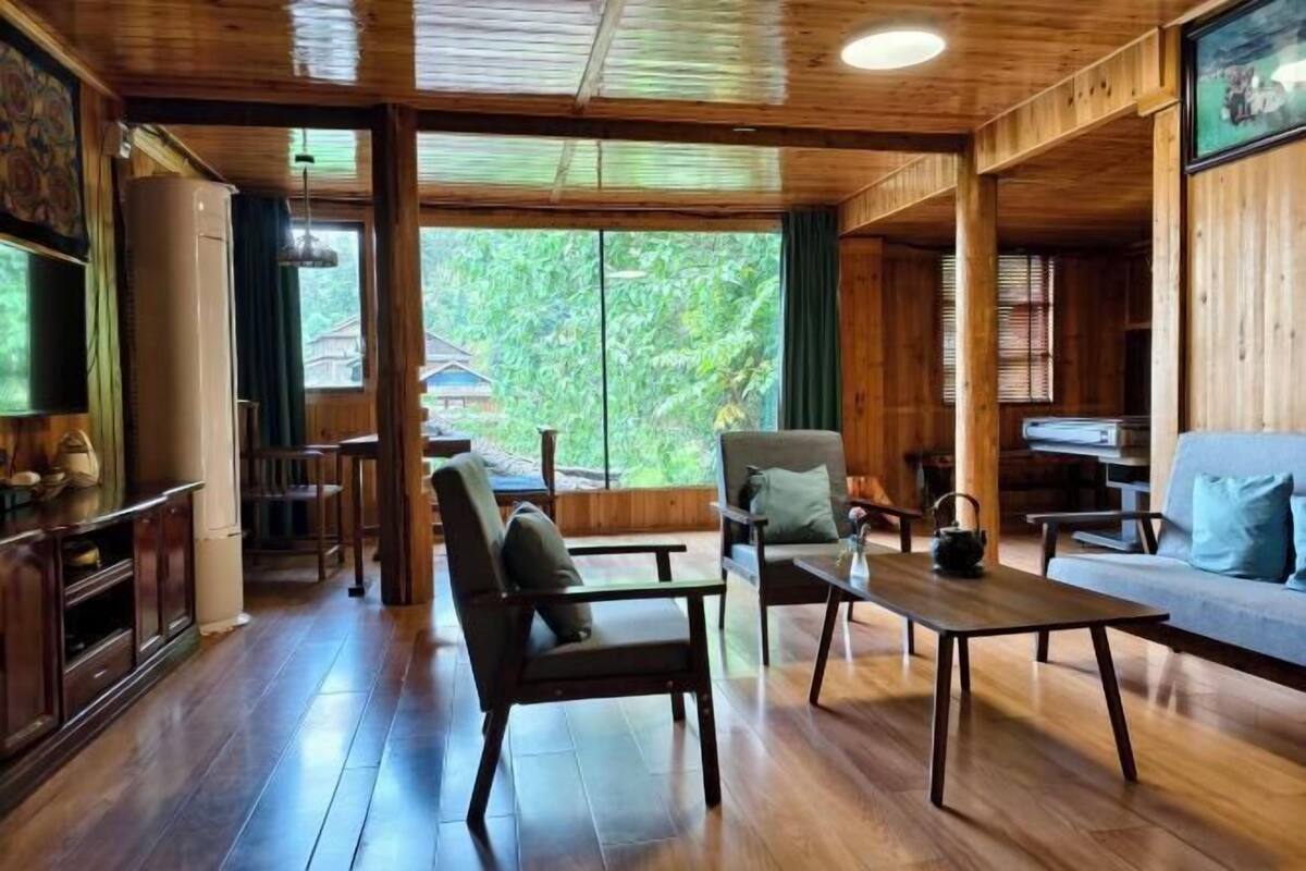 A spacious room with wooden floors, a sofa, a coffee table, and a television.
