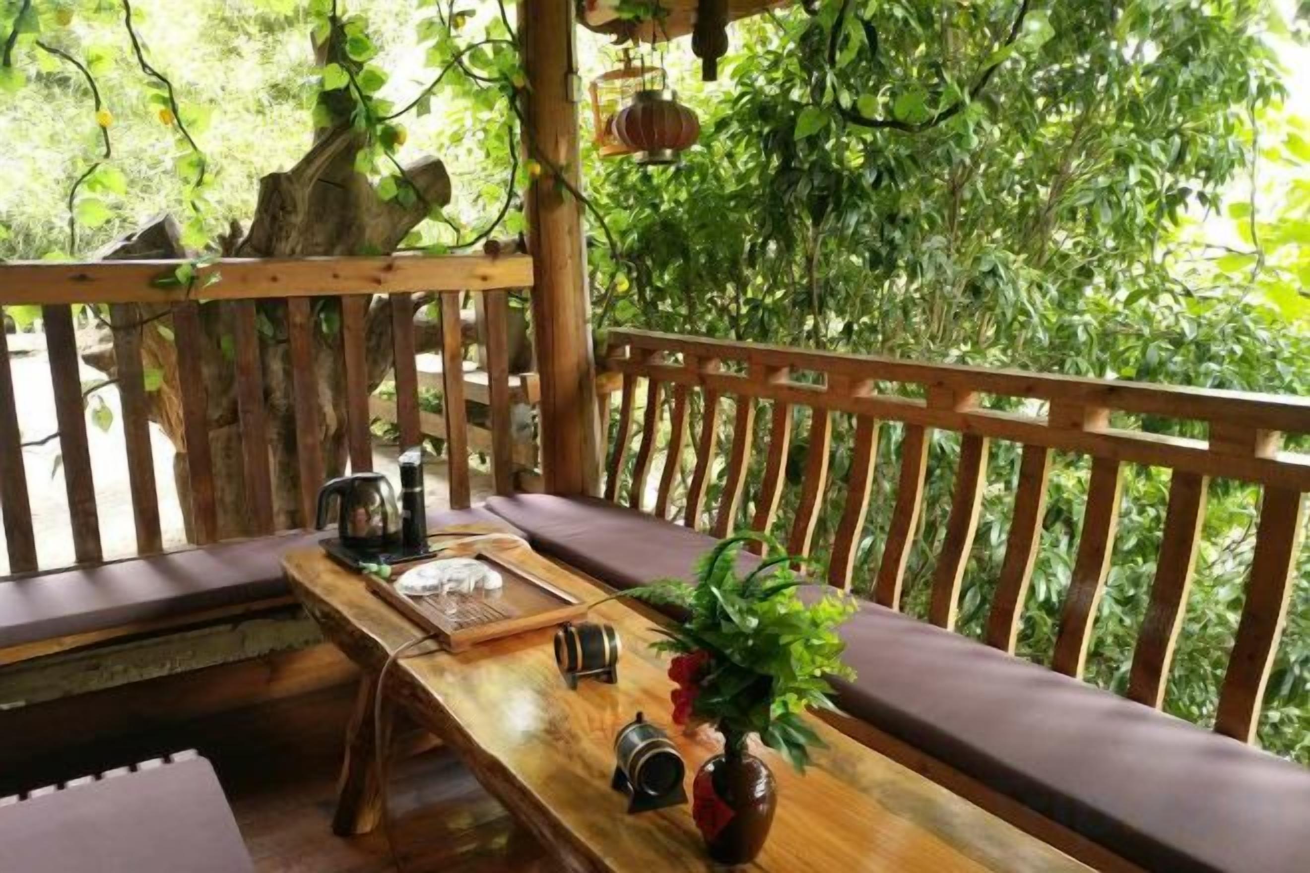 A wooden deck with a bench, a table with a plant, and a hanging lantern.