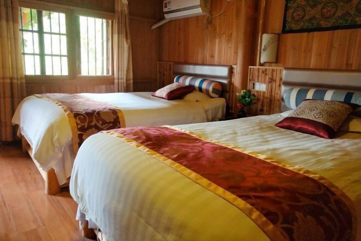 Ein Zimmer mit Holzboden und zwei Betten, jedes mit einer anderen Bettdecke.