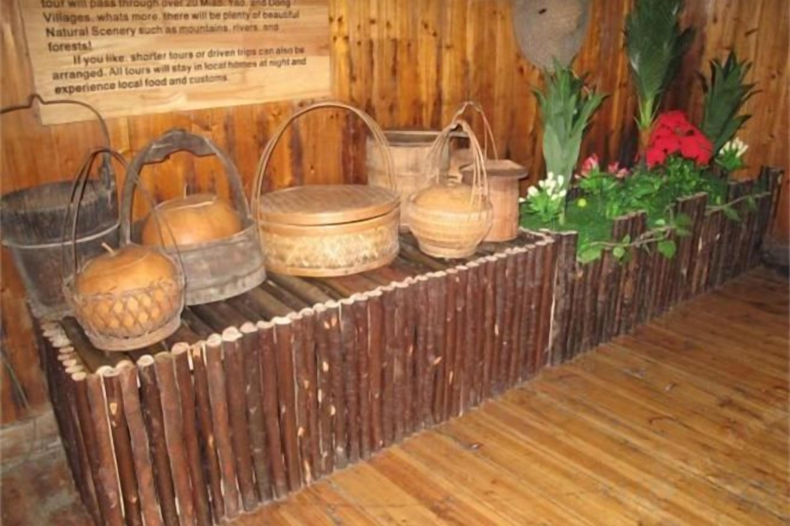 Exhibición de contenedores de madera tradicionales y un letrero en un entorno rústico.