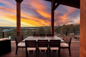 Un espacio de estar al aire libre techado, con una mesa y sillas, con vistas a un paisaje pintoresco.