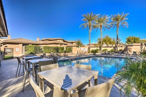 Relax by the pool surrounded by palm trees and lounge chairs.