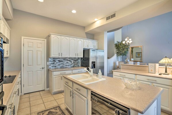 Enjoy cooking in this well-lit kitchen with a double sink, stainless steel appliances, and a large window.
