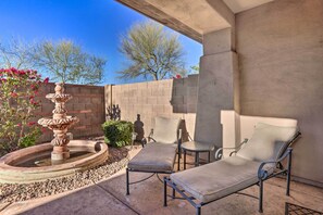 Relax by the soothing fountain surrounded by lush greenery and comfortable lounge chairs.
